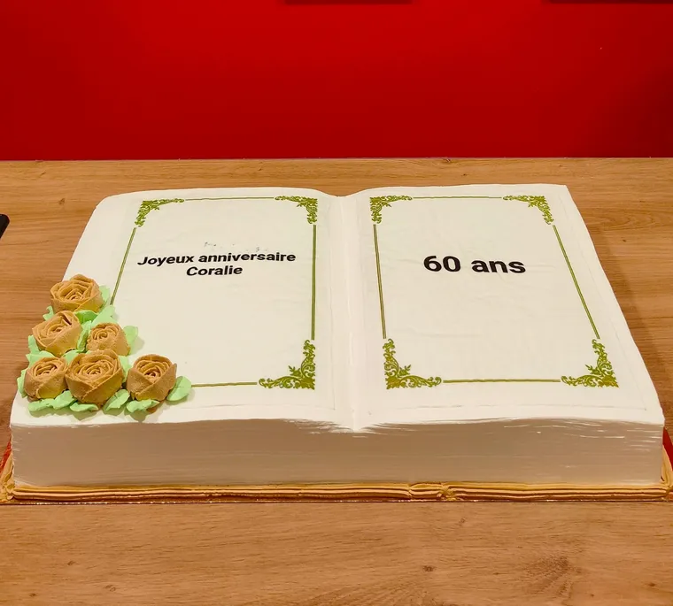 Gâteau sculpté en livre ouvert, pages blanches encadrées de dorures et roses à la poche